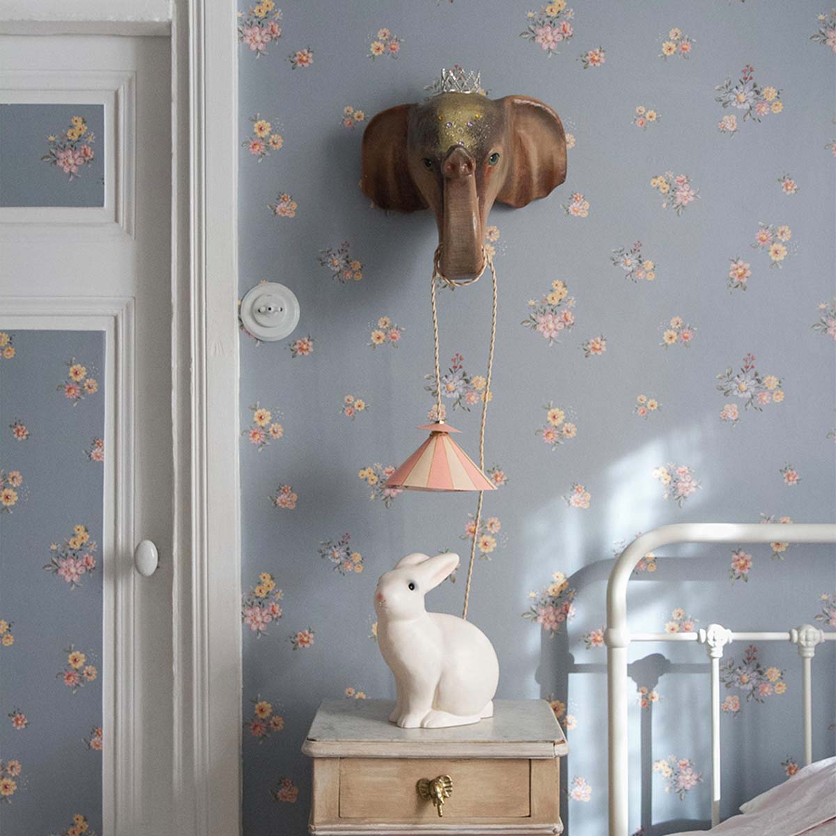 Dekornik Flowers Minimini Dark Behang — Een fijn behang met kleine bloemetjes in een mini-patroon op een donkere achtergrond, perfect voor een sfeervolle, botanische kinderkamer. Sfeerbeeld van het behang in een ingerichte kinderkamer.