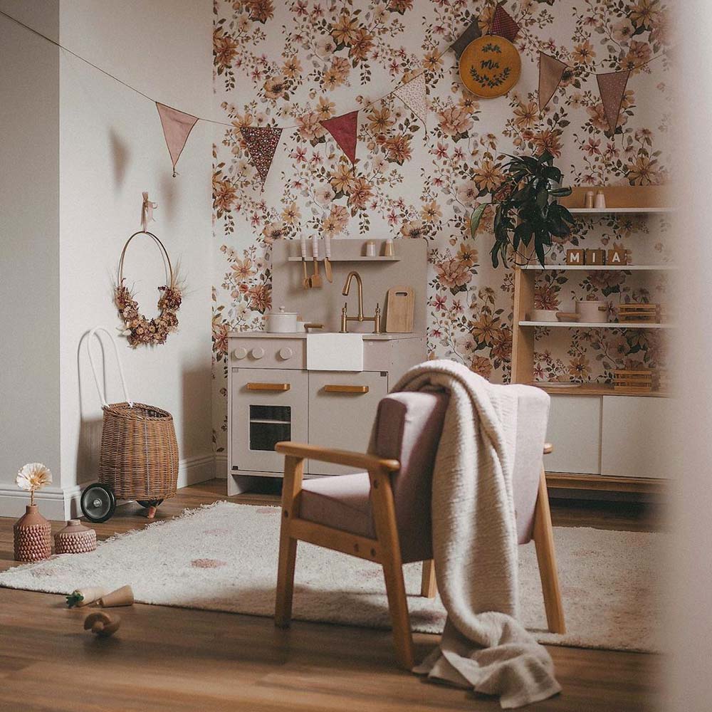 Dekornik Behang English Garden — Een sierlijk behang geïnspireerd op een Engelse tuin, met bloemen, bladeren en botanische ranken in zachte kleuren, perfect voor een tijdloze, romantische kinderkamer. Sfeerbeeld van het behang in een ingerichte kinderkamer.