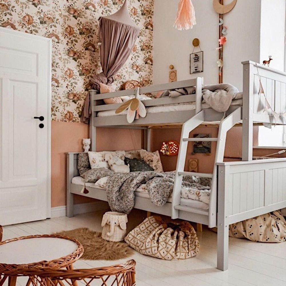 Dekornik Behang Little Sleepy Animals Light — Een zacht behang met slaperige dierenvriendjes die onder dekentjes en sterren liggen te dromen, in lichte pastelkleuren, perfect voor een rustgevende babykamer. Sfeerbeeld van het behang in een ingerichte kinderkamer.