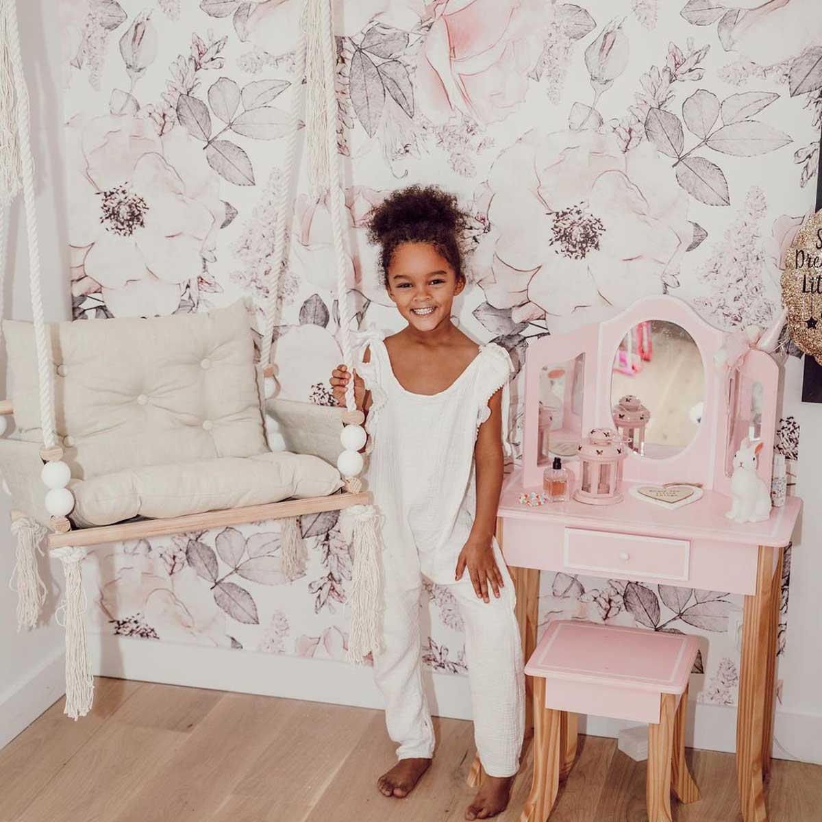 Dekornik Behang Pink Garden — Een behang vol bloeiende bloemen en twijgjes in zachte roze en groene tinten, perfect voor een romantische bloementuin-kinderkamer. Sfeerbeeld van het behang in een ingerichte kinderkamer.
