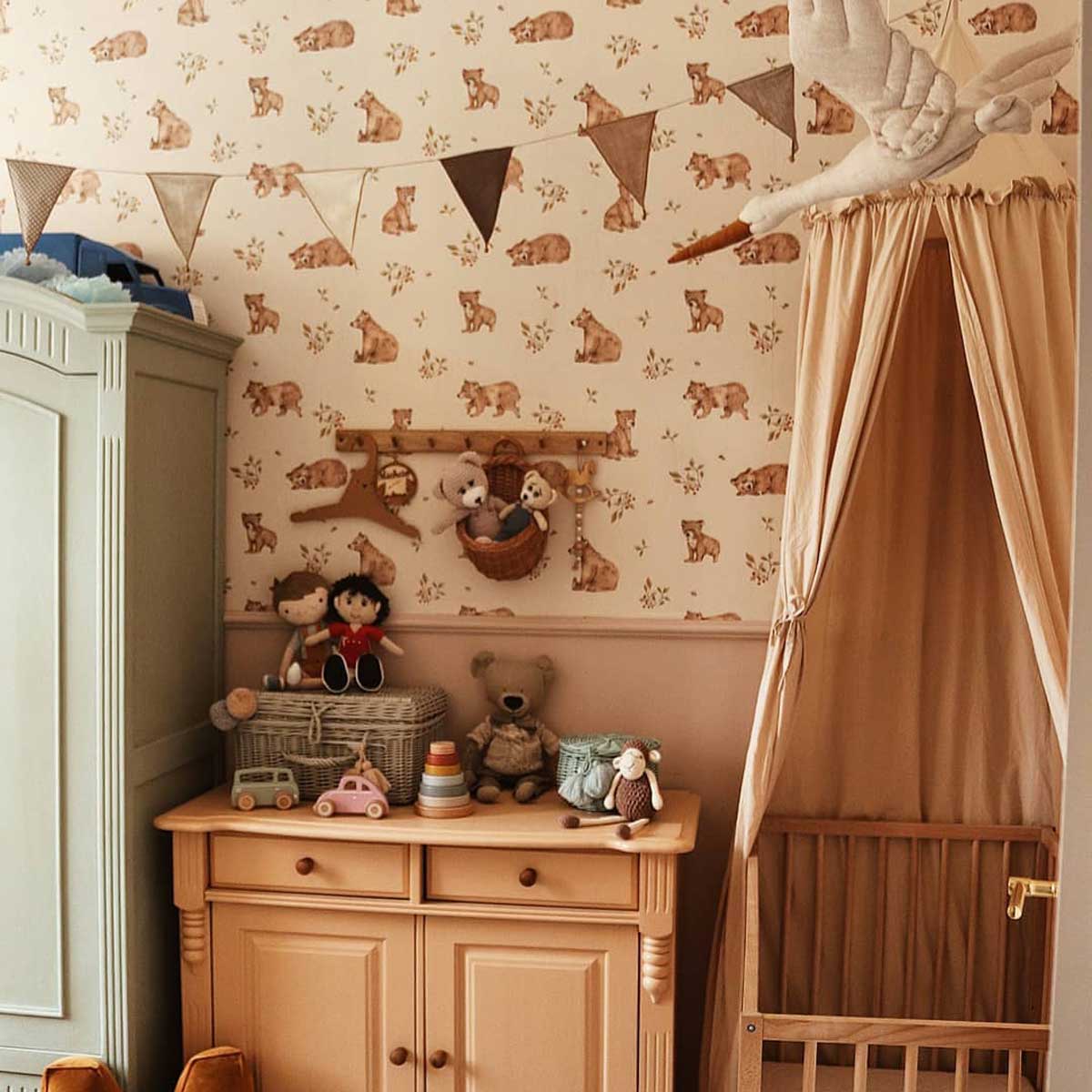 Dekornik Little Bears Behang — Een lief behang met kleine beertjes die spelen tussen bloemen en bomen, perfect voor een warme, knusse kinderkamer. Sfeerbeeld van het behang in een ingerichte kinderkamer.