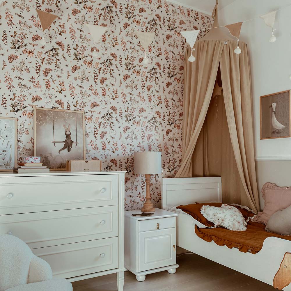 Dekornik Botanical Orchard Behang — Een sierlijk behang met boomgaardmotieven — bloesemtakken en fruitbomen — in zachte tinten, perfect voor een botanische, lichte kinderkamer. Sfeerbeeld van het behang in een ingerichte kinderkamer.