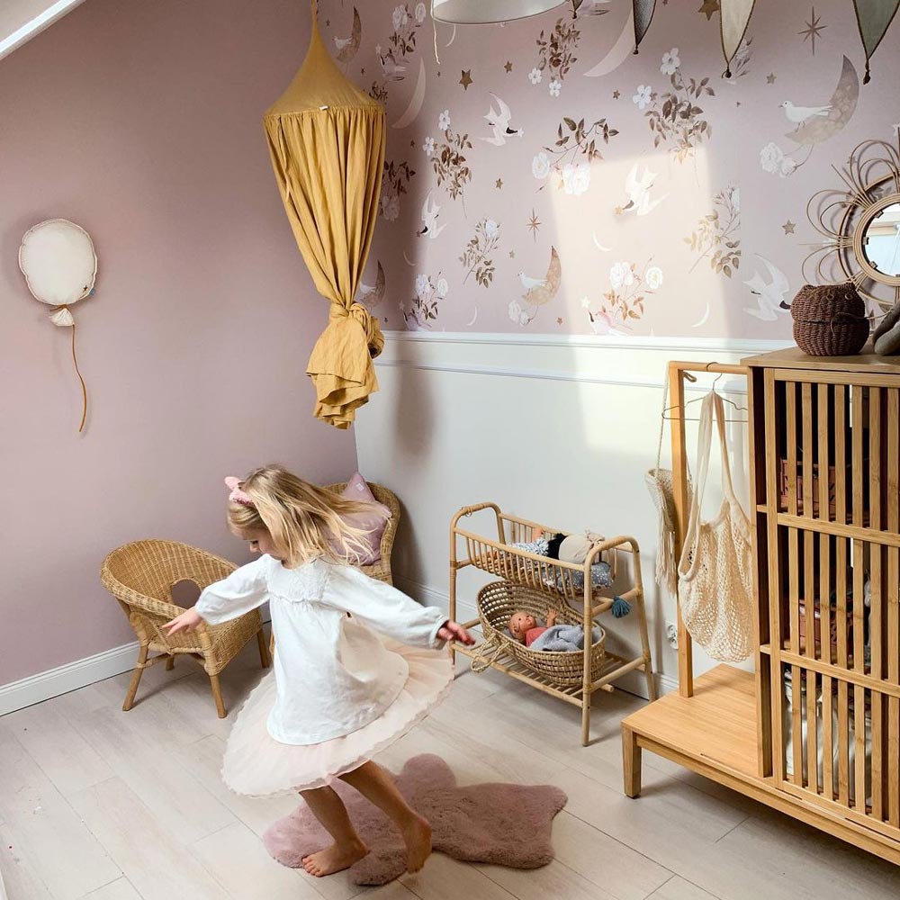 Dekornik Birds In The Night Sky — Een dromerig behang met vogeltjes die door een sterrenhemel vliegen, in diepe blauwtinten, perfect voor een rustgevende nachtelijke kinderkamer. Sfeerbeeld van het behang in een ingerichte kinderkamer.