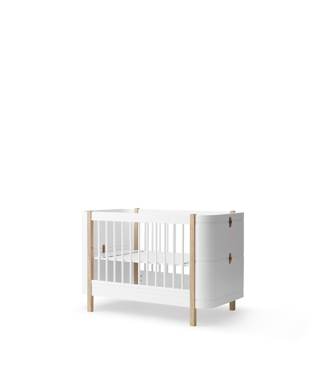 Oliver Furniture Wood Mini+ Cot Bed White/Oak in white/oak in een rustige Scandinavische babykamer met naturel houten vloer