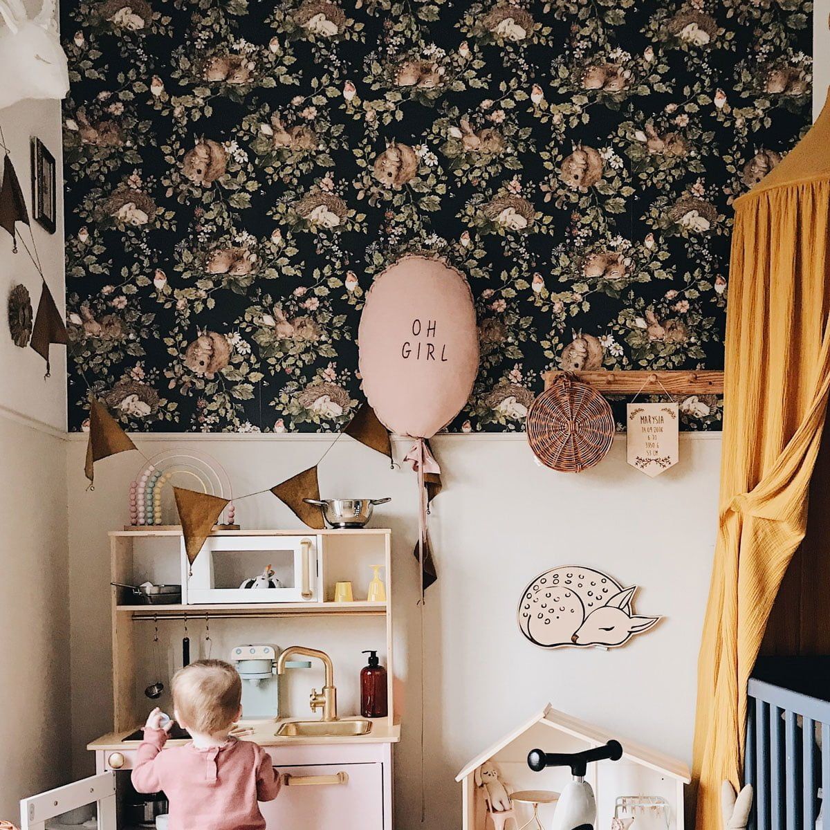 Dekornik Little Sleepy Animals Dark Behang — Een sfeervol behang met slaperige dierenvriendjes onder een donkere sterrenhemel, perfect voor een rustige, dromerige babykamer. Sfeerbeeld van het behang in een ingerichte kinderkamer.