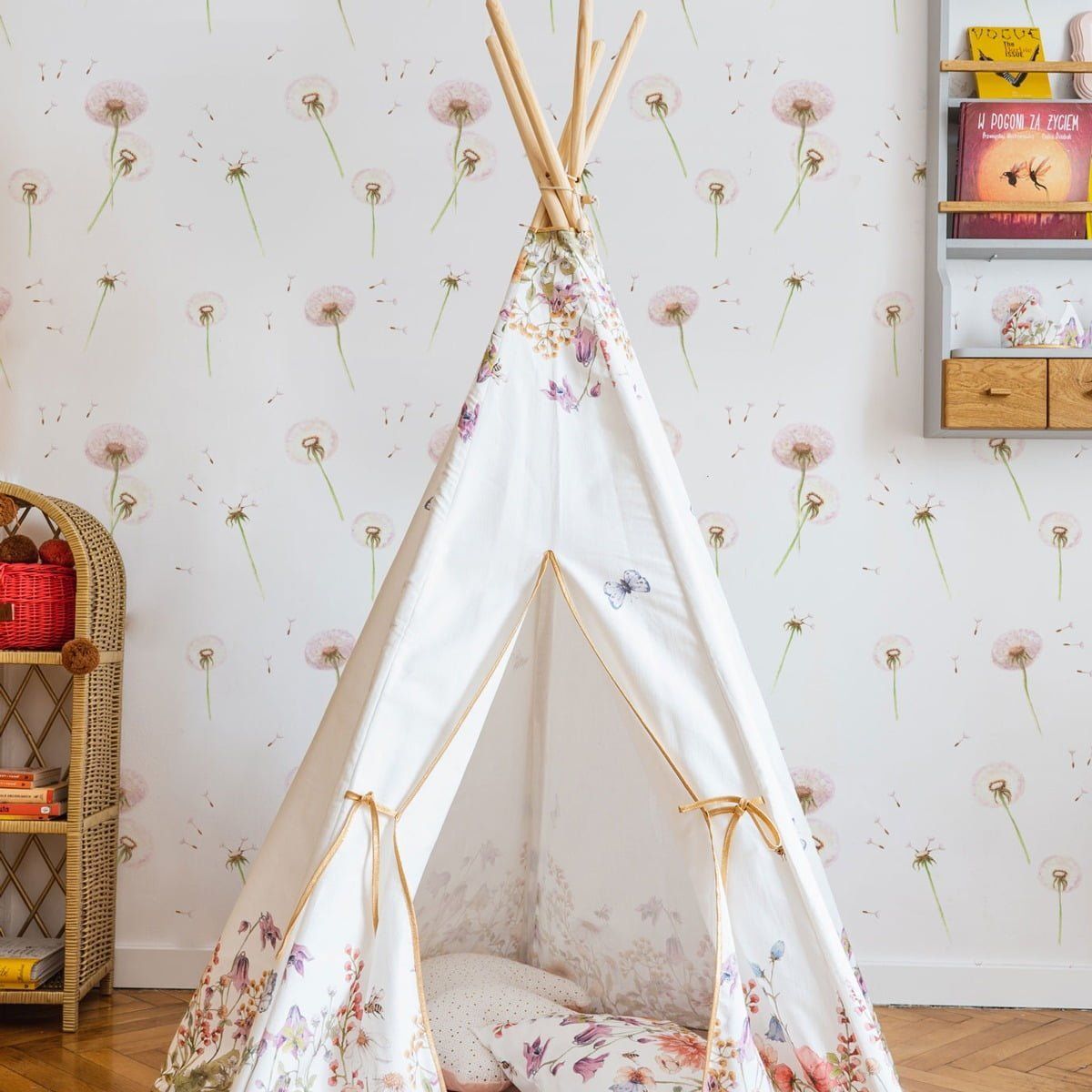 Dekornik Behang Dandelions — Een luchtig behang met paardenbloemen en zwevende pluisjes in zachte pastelkleuren, perfect voor een dromerige, botanische kinderkamer. Sfeerbeeld van het behang in een ingerichte kinderkamer.