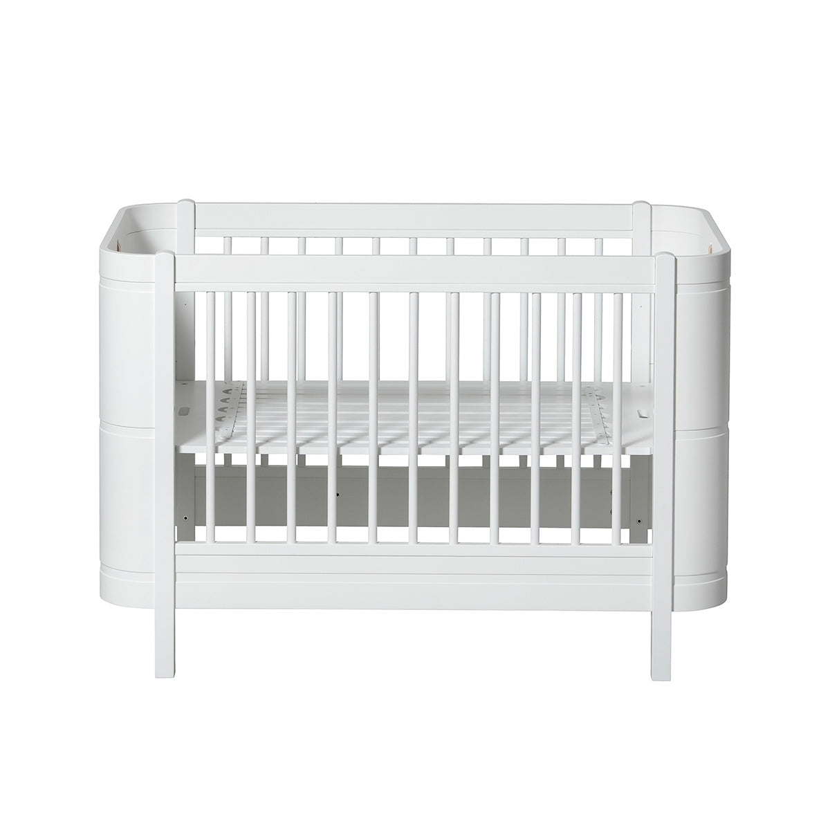 Oliver Furniture Wood Mini+ Cot Bed Excl. Junior Kit White opgesteld in een lichte Scandinavische kinderkamer