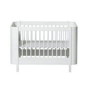 Oliver Furniture Wood Mini+ Cot Bed Excl. Junior Kit White opgesteld in een lichte Scandinavische kinderkamer