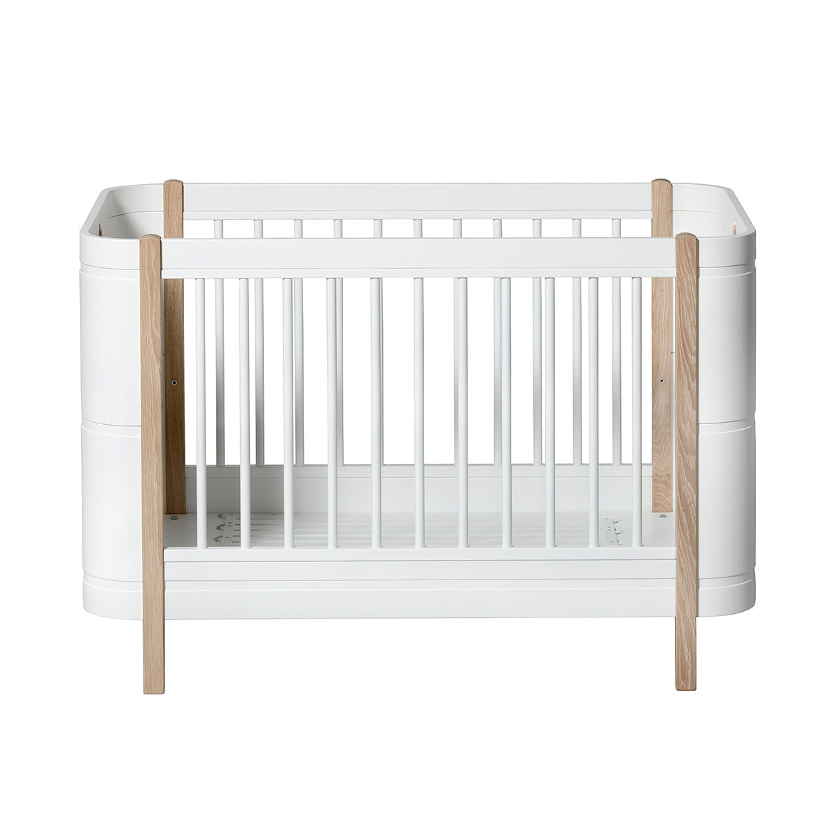 Oliver Furniture Wood Mini+ Cot Bed Excl. Junior Kit White/oak opgesteld in een lichte Scandinavische kinderkamer
