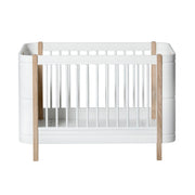 Oliver Furniture Wood Mini+ Cot Bed Excl. Junior Kit White/oak opgesteld in een lichte Scandinavische kinderkamer