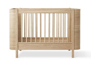 Oliver Furniture Wood Mini+ Cot Bed Excl. Junior Kit Oak opgesteld in een lichte Scandinavische kinderkamer