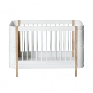 Oliver Furniture Wood Mini+ Cot Bed Incl. Junior Kit White/oak opgesteld in een lichte Scandinavische kinderkamer