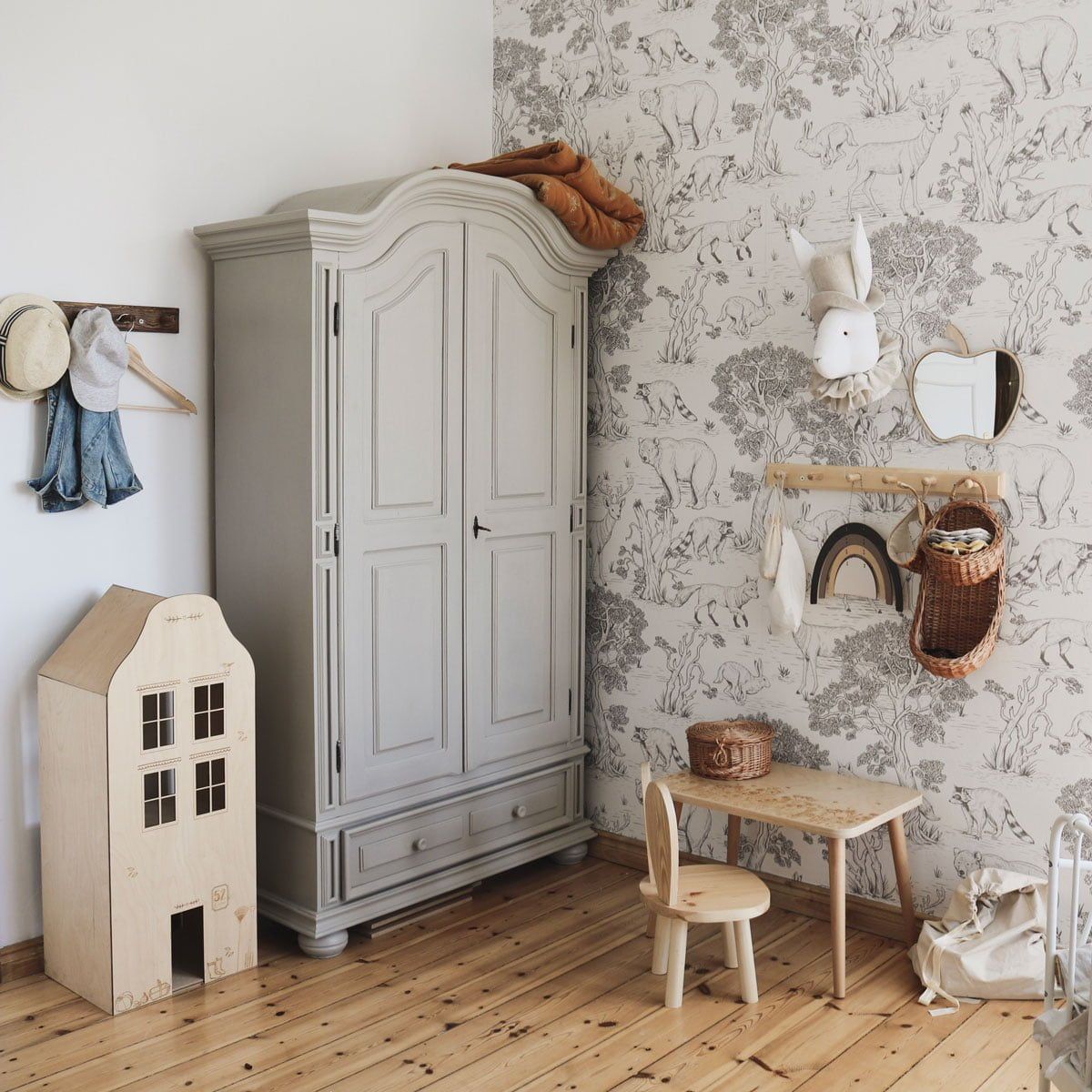 Dekornik Behang Animals White — Een speels behang met schattige dierenvriendjes — konijntjes, beertjes en vogeltjes — getekend in zachte lijnen op een witte achtergrond, perfect voor een vrolijke, lichte kinderkamer. Sfeerbeeld van het behang in een ingerichte kinderkamer.